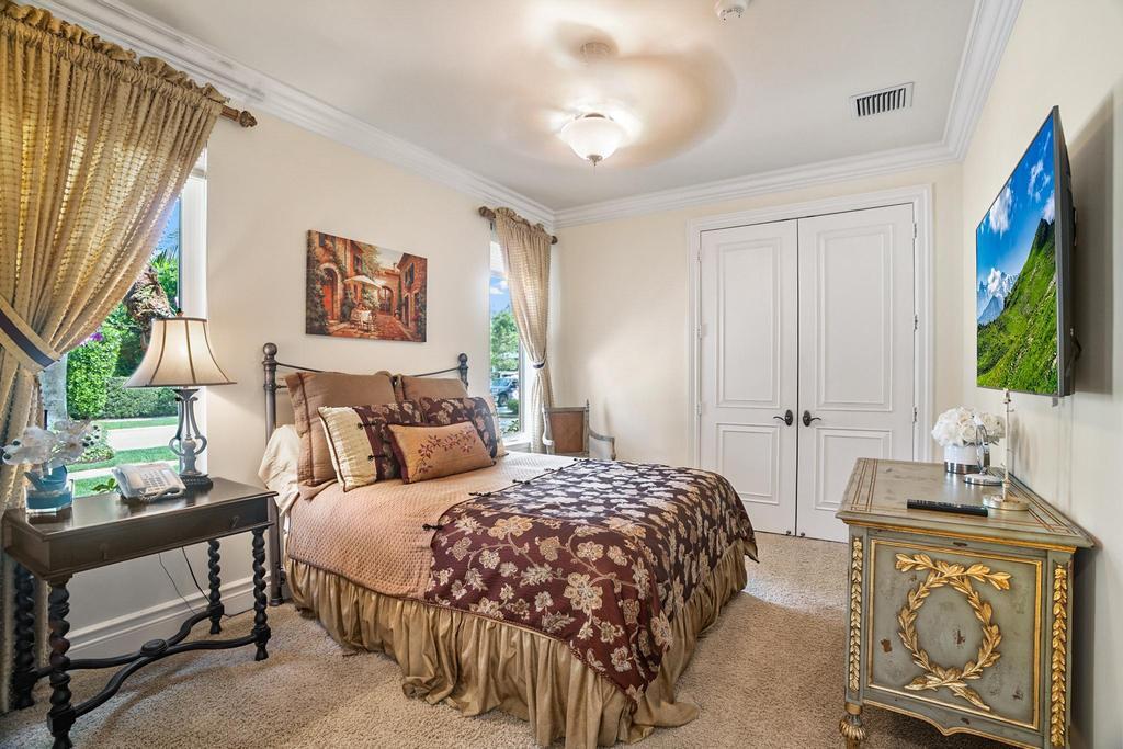 17542 Grand Este Way Boca Raton, FL 33496 - Photo 44 of 45 a bedroom with a bed a couch and a flat tv screen on dresser