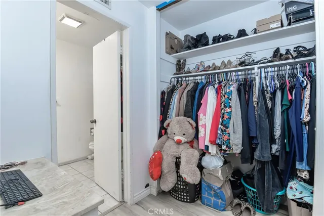 a view of walk in closet with clothes and shoes