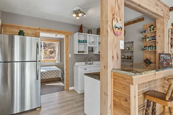 a kitchen view with stainless steel appliances granite countertop a refrigerator and a stove top oven