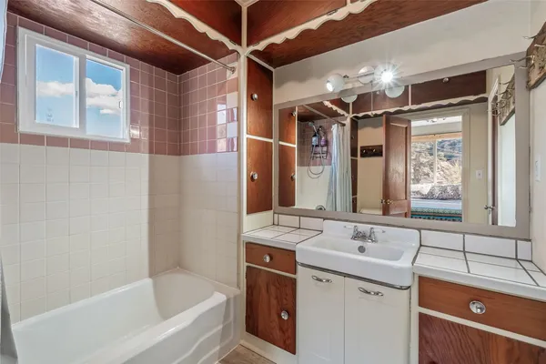 a bathroom with a tub sink and mirror