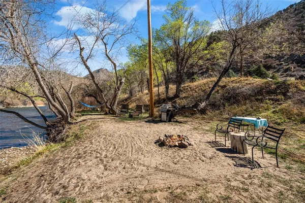 a view of a backyard with wooden fence and a large tree