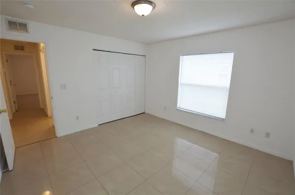 an empty room with windows and closet