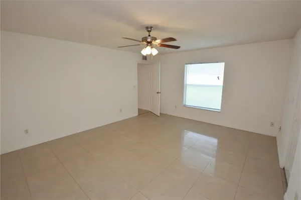 an empty room with a window and a fan