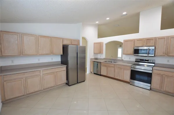 a kitchen with stainless steel appliances a refrigerator sink and cabinets