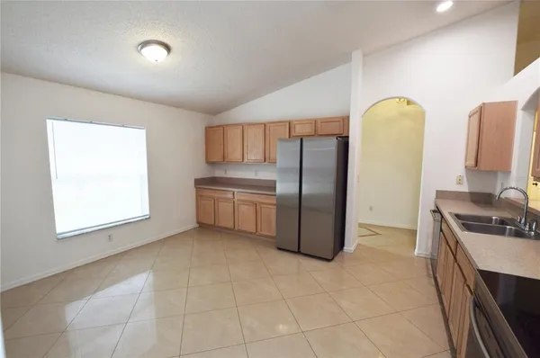 a kitchen with stainless steel appliances granite countertop a refrigerator a sink a stove with white cabinets