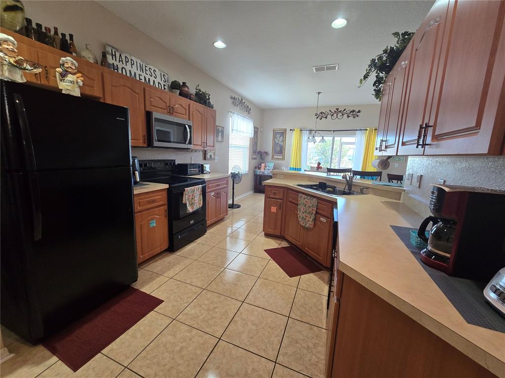 219 Cloverdale Road Winter Haven, FL 33884 - Photo 8 of 29 a kitchen with stainless steel appliances granite countertop a stove a sink and a refrigerator