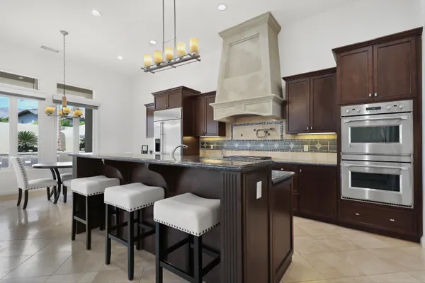 a kitchen with granite countertop a stove a sink and cabinets