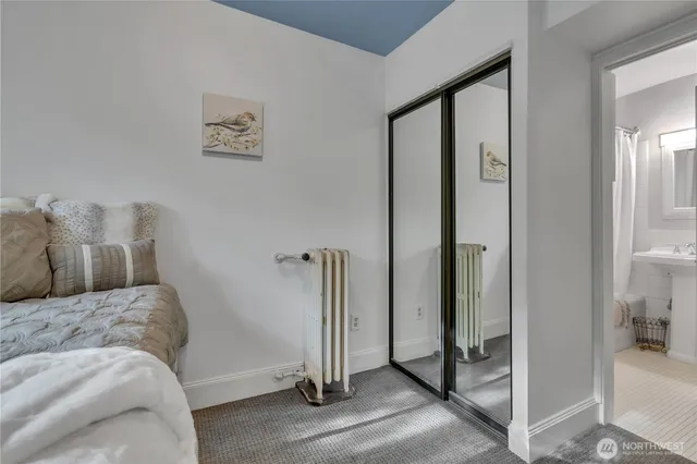 a bedroom with a bed and a painting on the wall