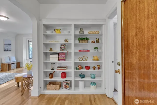 a cabinet with a book shelf and a bathroom view