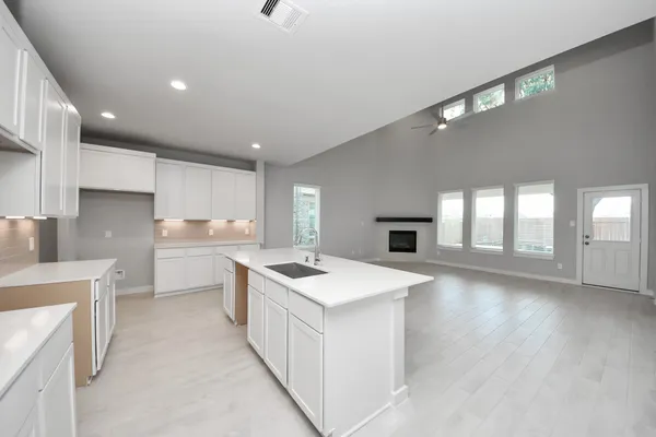 an empty room with windows and fireplace