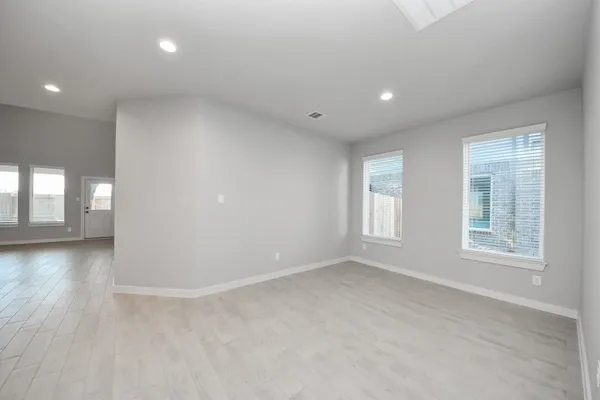 a kitchen with a sink dishwasher a stove and white cabinets with wooden floor