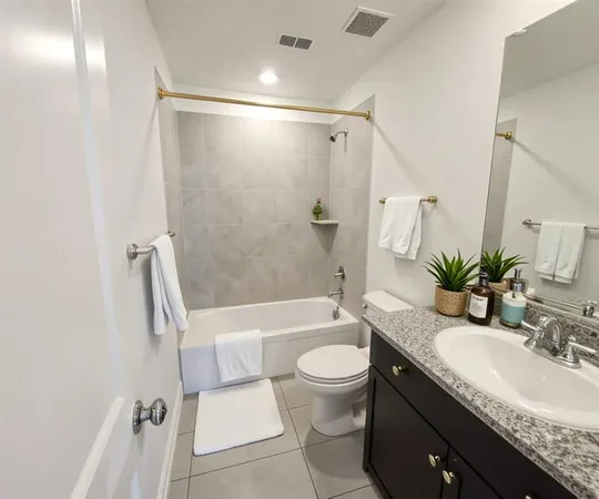 a bathroom with a granite countertop sink toilet and shower