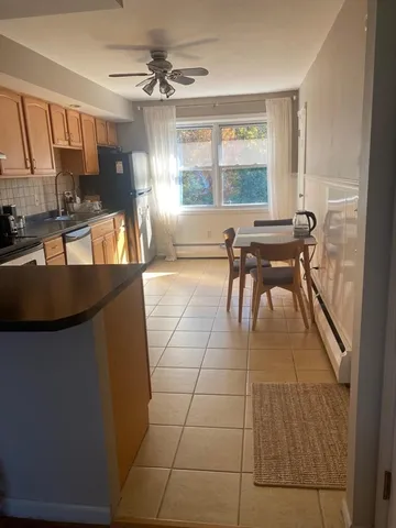 a view of a kitchen counter space a sink wooden floor and living room view