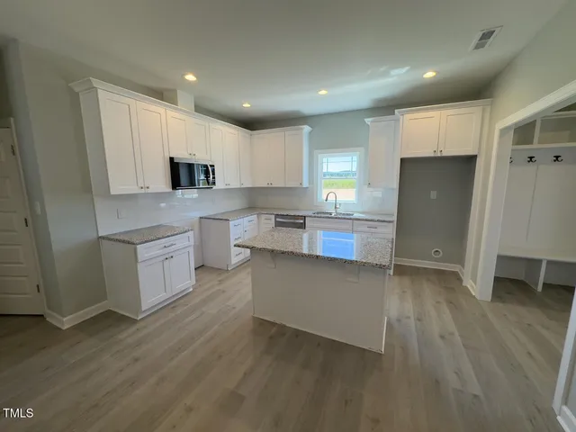 a kitchen with a sink a refrigerator and cabinets