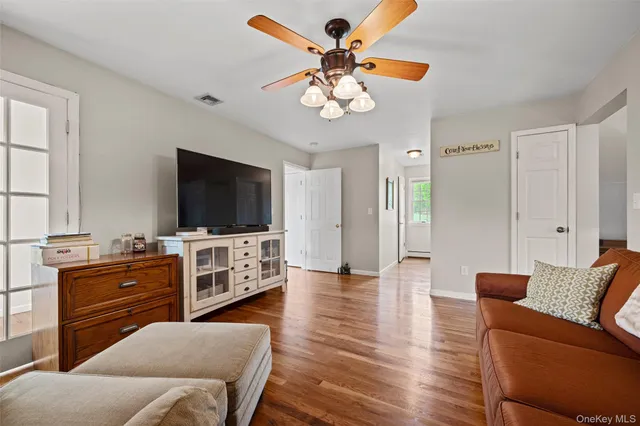 a living room with wooden floor furniture and a window