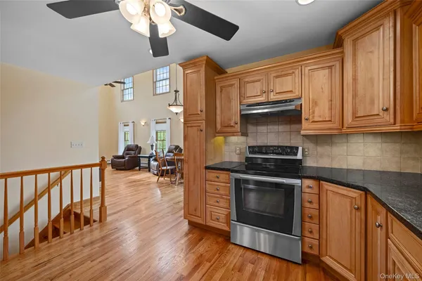 a kitchen with stainless steel appliances granite countertop a stove and a wooden floors