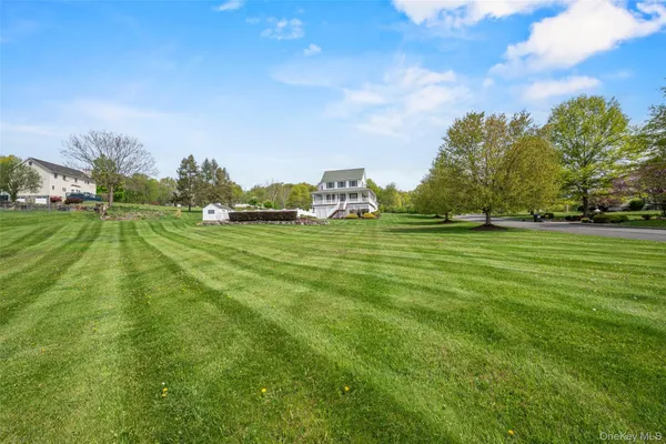 a view of a house with a big yard plants and large trees