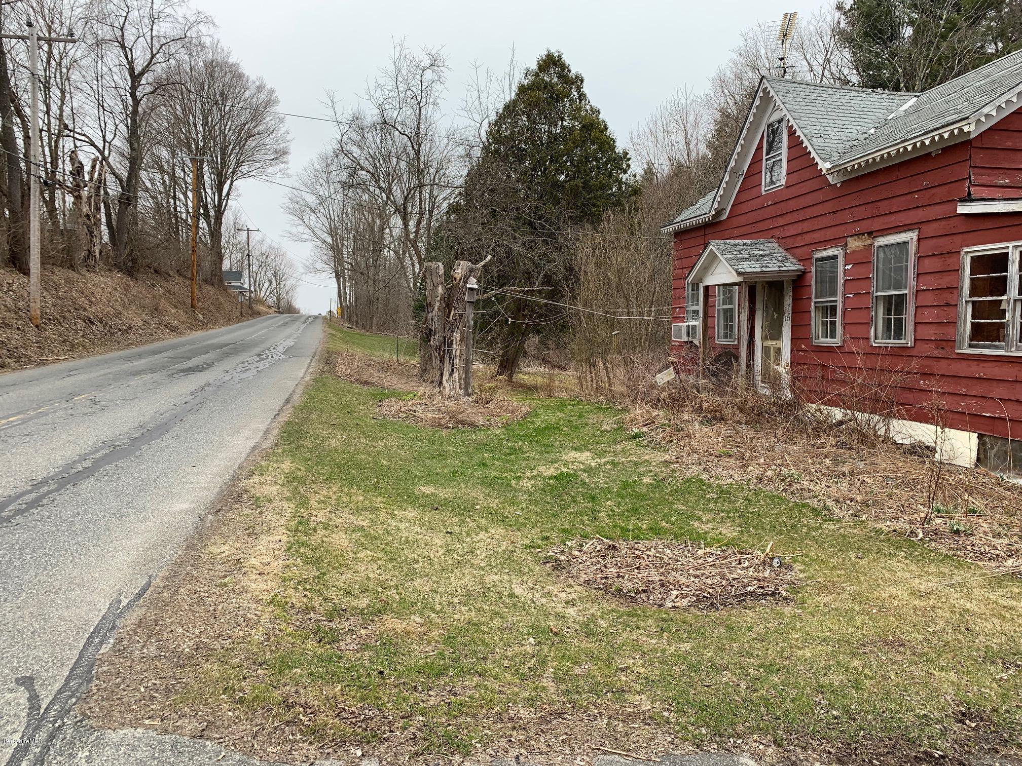 135 Main Road Tyringham, MA 01264 - Photo 2 of 8 a backyard of a house with large trees and covered by side of it