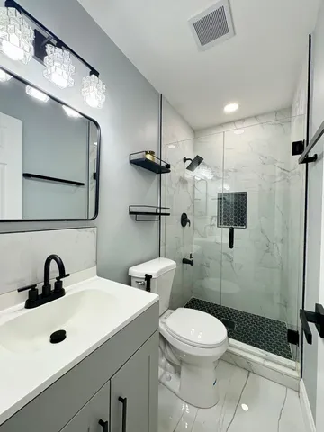 a bathroom with a sink a toilet and shower