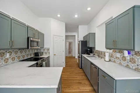 a large kitchen with kitchen island a sink stainless steel appliances and cabinets
