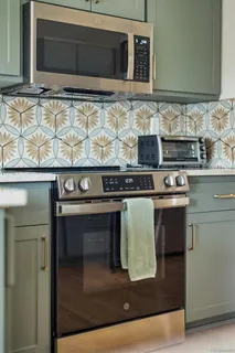 a kitchen with granite countertop a stove and a microwave