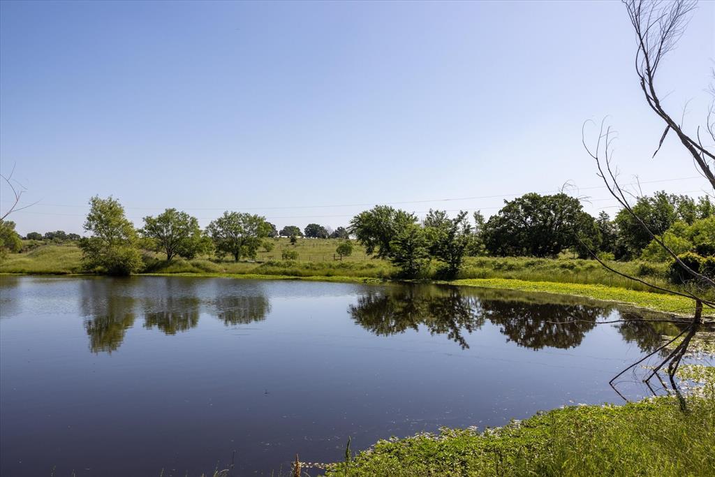 11701 Bowden Road Lipan, TX 76462 - Photo 8 of 26 a view of a lake with a house in the background