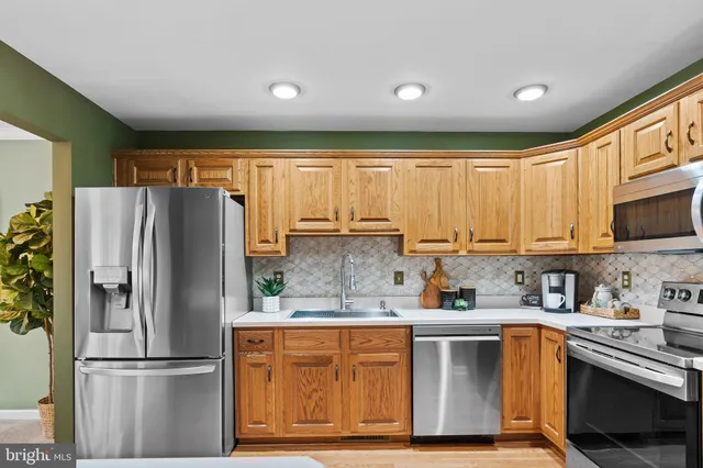 a kitchen with stainless steel appliances granite countertop a refrigerator oven a sink and dishwasher
