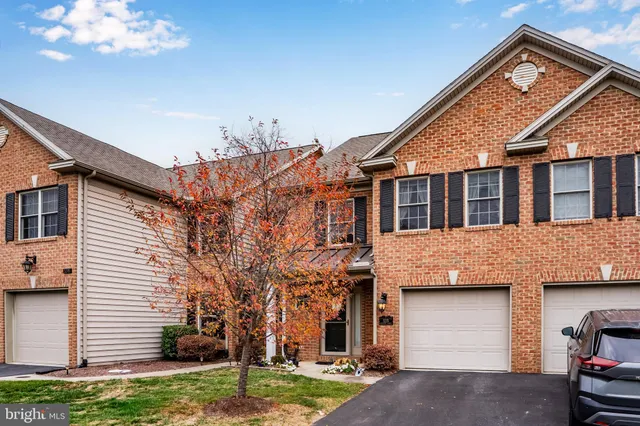 a view of a white house next to a yard