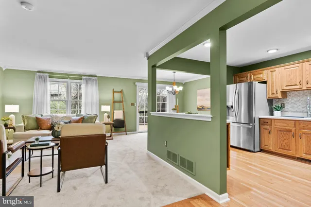 a living room with furniture a large window and wooden floors