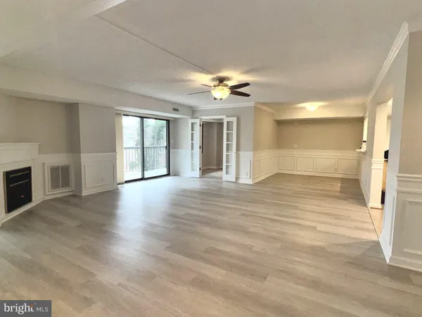 a view of a big room with wooden floor and a kitchen