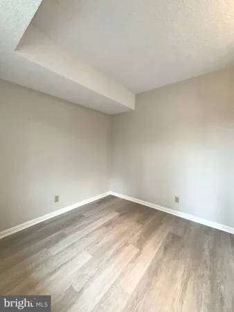 an empty room with a window and ceiling fan
