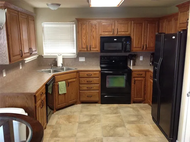 a kitchen with granite countertop a refrigerator and a stove