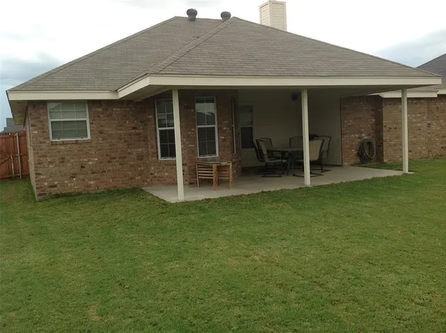 a backyard of a house with table and chairs