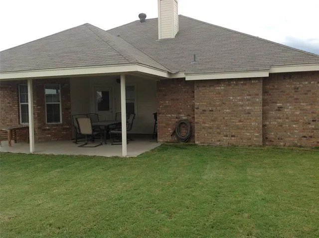 a backyard of a house with table and chairs