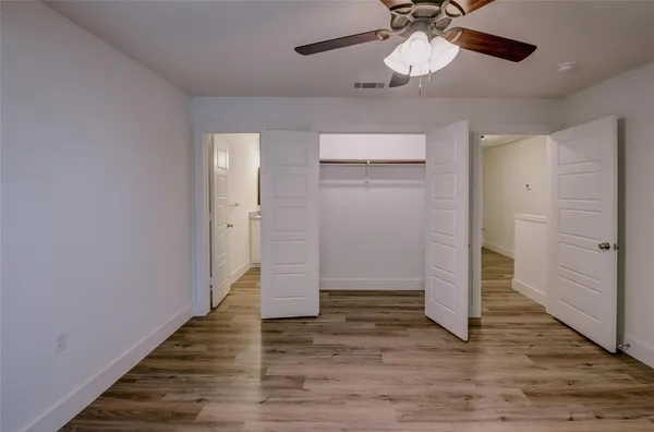 en empty room with fan and a ceiling fan