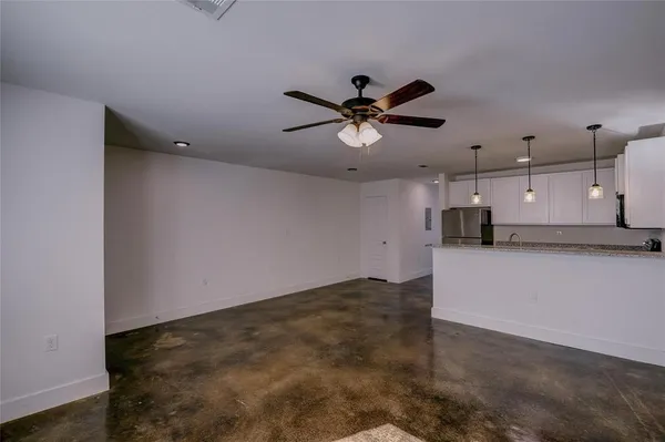 a view of a kitchen with a sink and a ceiling fan