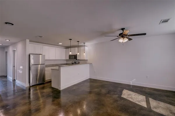 a kitchen with a refrigerator and white cabinets