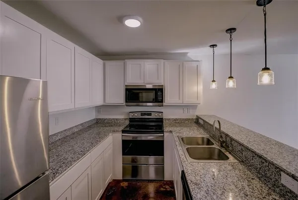 a kitchen with a sink a stove and a refrigerator
