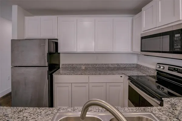a kitchen with a refrigerator stove and cabinets