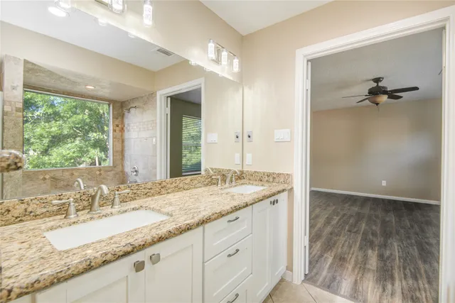 a bathroom with a granite countertop sink mirror and a bath tub