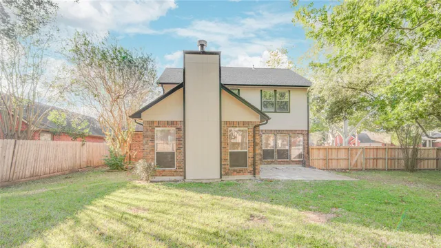a view of a house with a yard and wooden fence