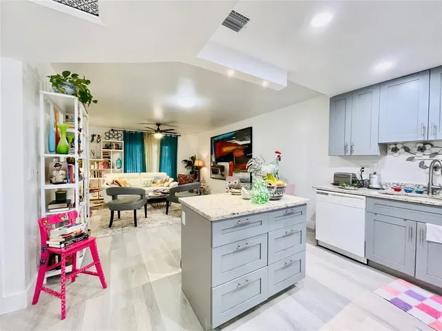 a living room with kitchen island furniture and a flat screen tv