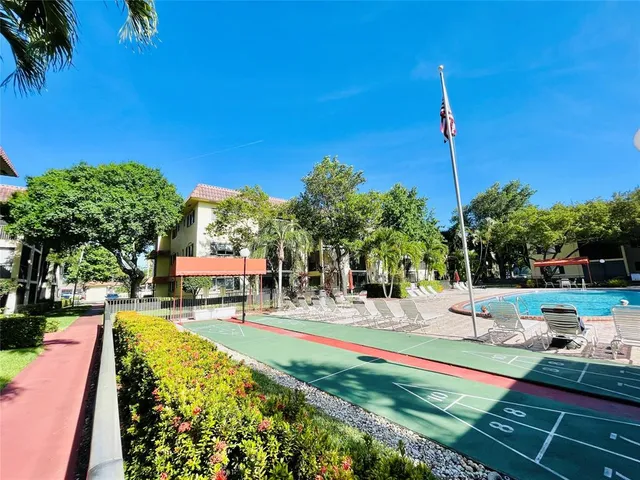 a view of a multi story residential apartment building with a yard