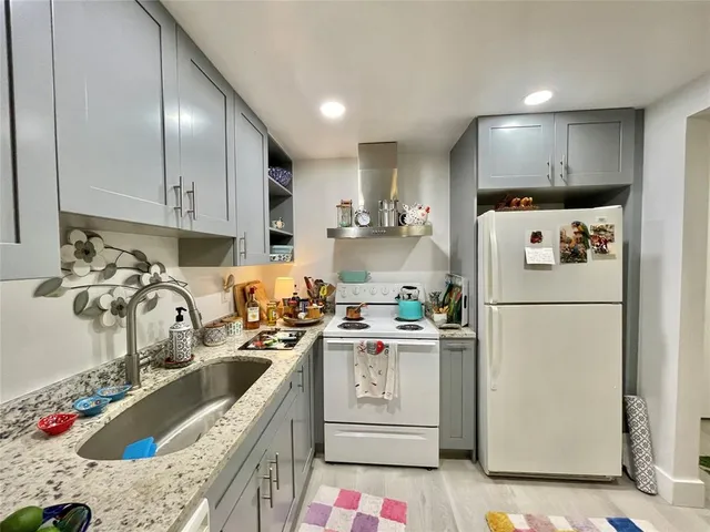 a kitchen with granite countertop a sink stainless steel appliances and cabinets