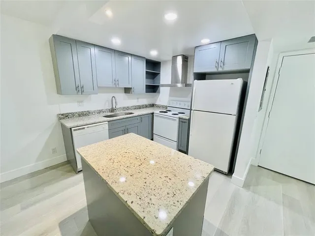 a kitchen with a stove a sink a refrigerator and cabinets
