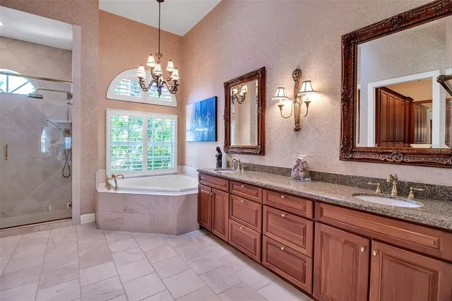 a spacious bathroom with a granite countertop sink a toilet a mirror and bathtub