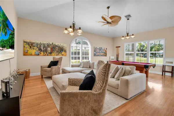 a living room with furniture chandelier and a large window