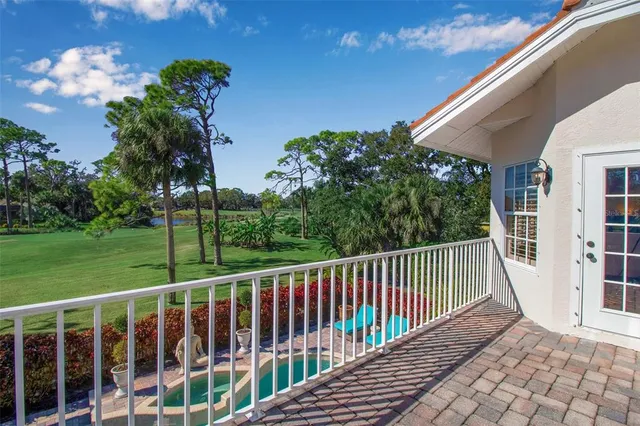 a view of a balcony with a floor to ceiling window and tree