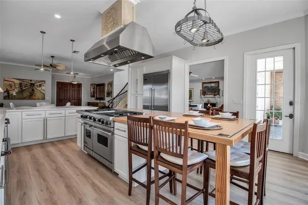 a kitchen with stainless steel appliances a kitchen island a stove a table and chairs in it
