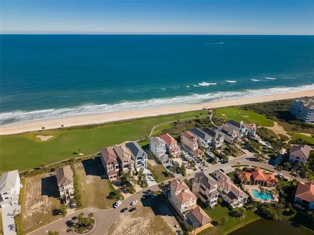 an aerial view of a house with a yard and lake view